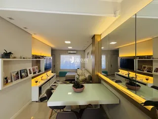 Ambiente moderno de sala de estar com decoração clara e iluminação embutida.