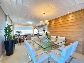 Uma sala de jantar com mesa de vidro e cadeiras brancas em um ambiente com painel de madeira.