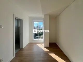 Foto de um corredor interno com piso de madeira e uma janela com vista para a cidade.