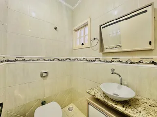 Foto de um banheiro com revestimento cerâmico nas paredes.