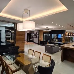 Foto do interior de uma sala de estar com iluminação moderna e detalhes em madeira.