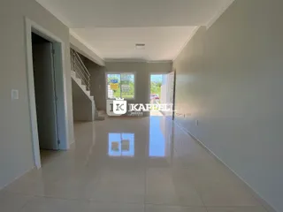 Hall de entrada com piso de cerâmica e escadaria visível.