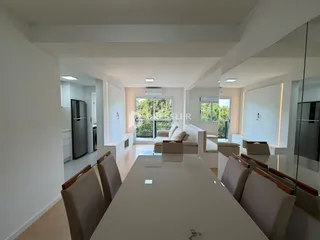 Ambiente interno de uma sala de estar moderna com grandes janelas.