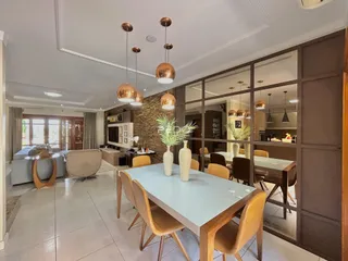 Uma sala de jantar ampla com mesa de madeira e cadeiras em um apartamento.