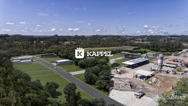 Vista aérea de um terreno comercial com vários edifícios e áreas verdes.
