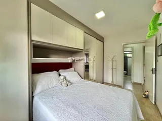 Quarto com cama e armários embutidos brancos.