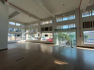 Interior de um grande espaço aberto com piso de concreto.