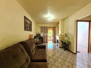 Sala de estar com sofá marrom e piso de cerâmica.