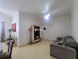 Foto de uma sala de estar ampla com piso de madeira clara.