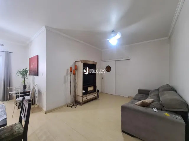 Foto de uma sala de estar ampla com piso de madeira clara.