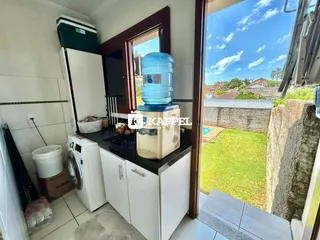 Foto de uma cozinha com armários brancos e máquina de lavar roupa.