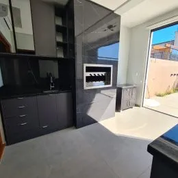 Sala de estar moderna com painel de lareira e armários escuros.