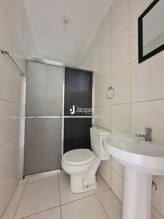 Foto de um banheiro com revestimento de cerâmica branca.
