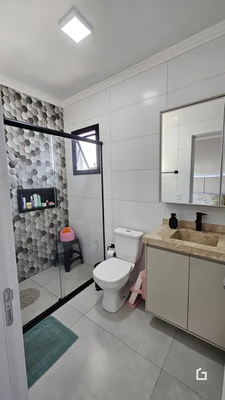 Foto de um banheiro moderno com piso de cerâmica e box de vidro.