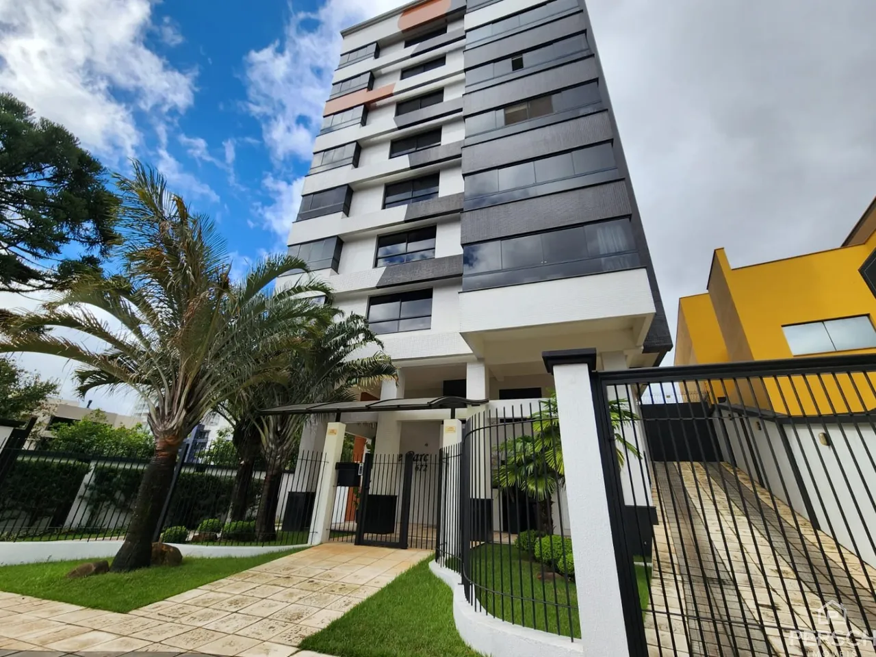 Fachada moderna de um prédio residencial em Lajeado, Brasil, com paisagismo frontal.
