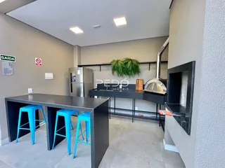 Cozinha moderna com ilha e bancada escura em um imóvel no Brasil.