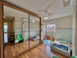 Quarto com piso de madeira e duas camas visíveis através de um espelho.