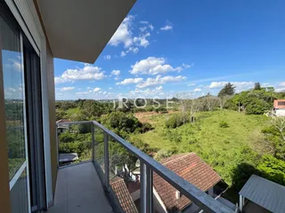 Vista da varanda com paisagem verde e céu azul.