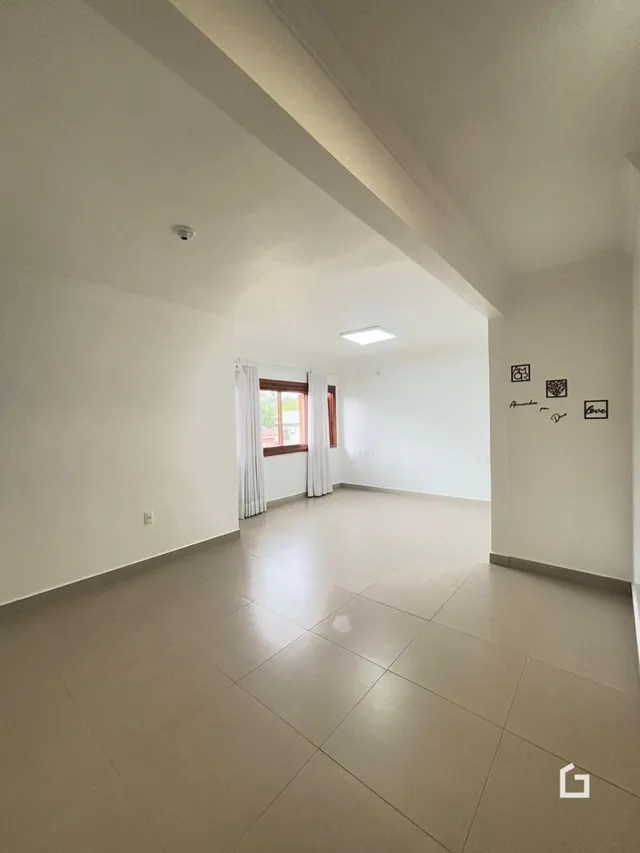 Um corredor amplo com piso de cerâmica claro.