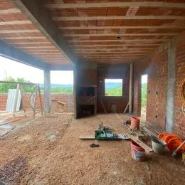 Foto de um interior em construção com estrutura de madeira exposta no teto.
