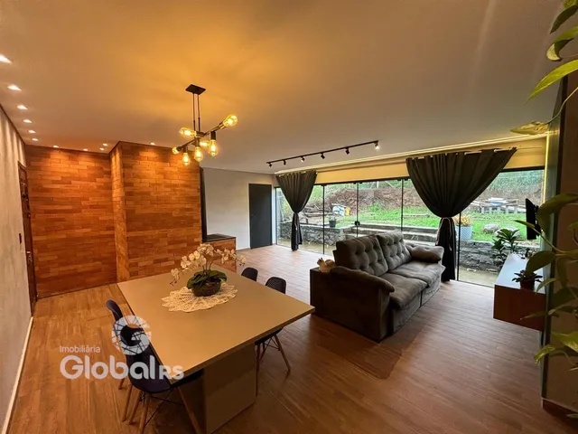 Sala de estar ampla com piso de madeira e portas de vidro que dão para o exterior.