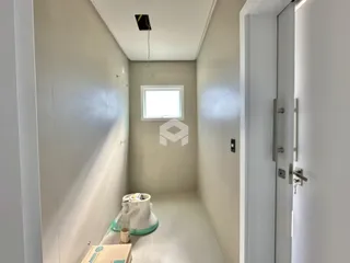 Vista de um corredor interno com paredes brancas em uma residência.