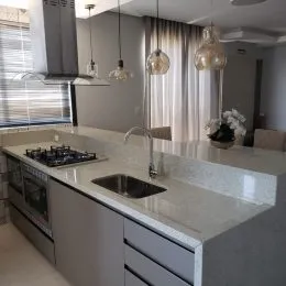 Foto de uma cozinha com bancada clara e armários modernos.