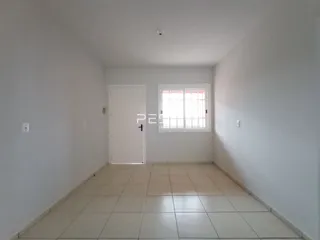 Ambiente interno de uma sala com piso de cerâmica e porta branca.