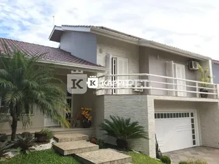 Fachada de uma residência em Lajeado, Brasil, com garagem e paisagismo.