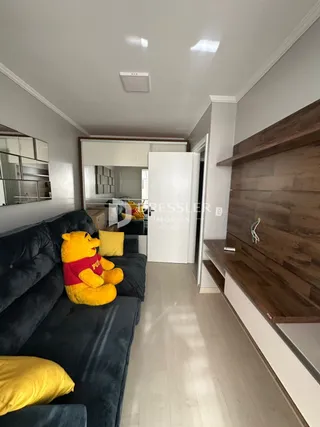 Sala de estar com sofá escuro e painéis de madeira.