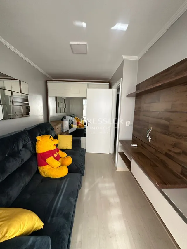 Sala de estar com sofá escuro e painéis de madeira.