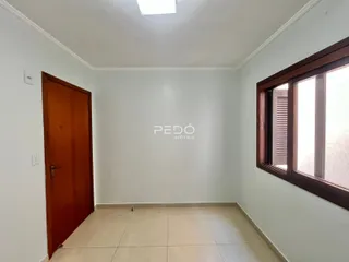 Ambiente interno de uma sala com piso de cerâmica e janela.