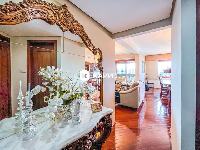 Foto de um corredor interno com piso de madeira polida e um espelho ornamentado.