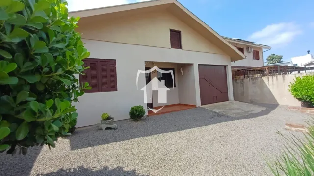 Fachada de uma residência em Lajeado, Brasil, com garagem e jardim frontal.