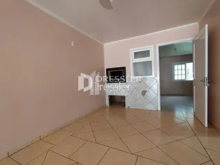 Interior de um corredor com piso de cerâmica claro.