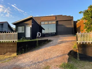 Vista da fachada de uma residência em Lajeado, Brasil, com cerca e entrada de terra.