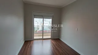 Interior de um ambiente com piso de madeira e porta de vidro.