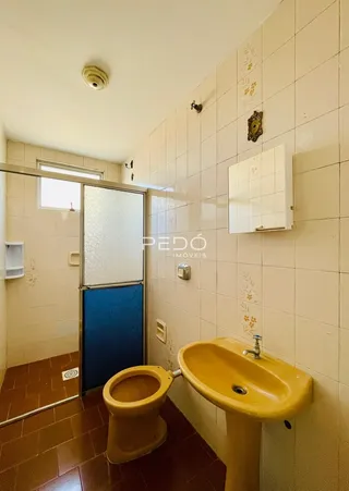 Foto interna de um banheiro com revestimento de cerâmica e piso de terracota.