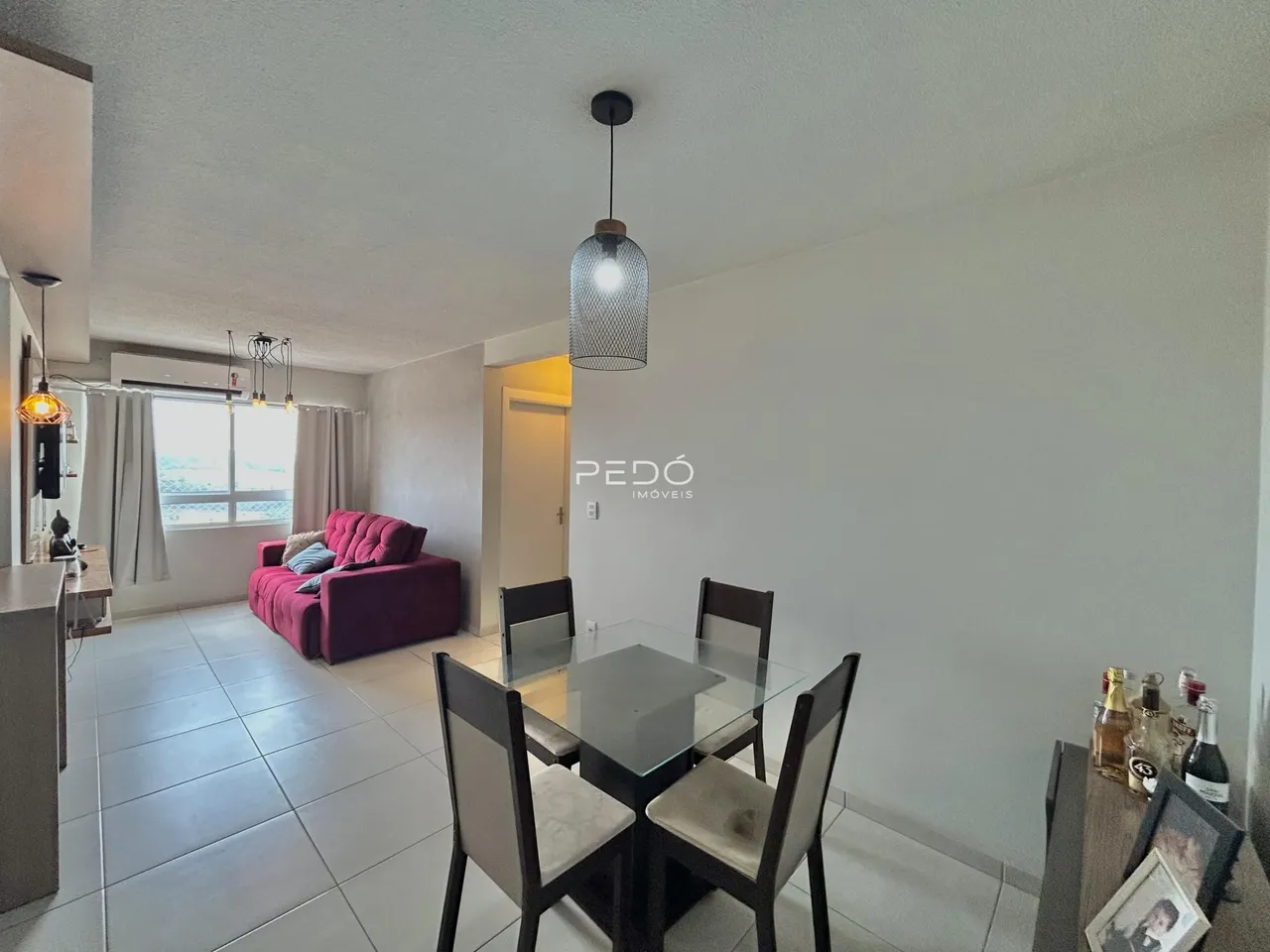 Sala de jantar com mesa de vidro e ambiente claro.