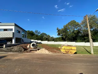 Vista externa de uma construção em Lajeado, Brasil, com terra e materiais no primeiro plano.