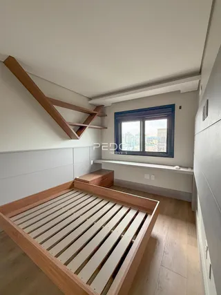 Quarto com estrutura de cama de madeira e janela no interior de uma residência.