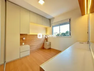Um quarto com armários brancos e piso de madeira clara.