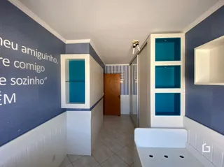 Hall de entrada com armários embutidos e porta de madeira.