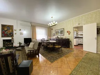Sala de estar com piso de madeira e lareira em uma residência.