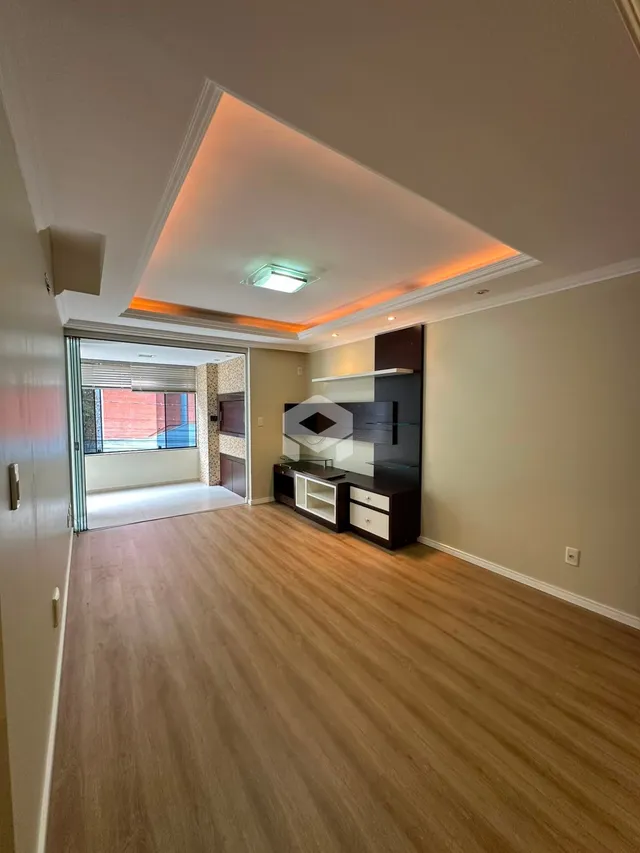 A sala apresenta piso de madeira e teto com iluminação embutida.