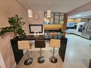 Ambiente interno de sala de jantar com mesa e bancos em um apartamento em Lajeado.