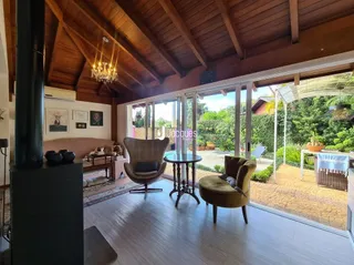 Sala de estar com teto de madeira e portas de vidro que dão para o quintal.