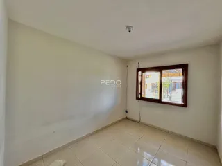 Interior de uma sala com piso de cerâmica e janela.