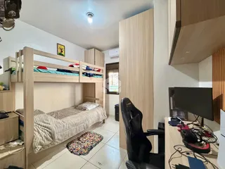 Quarto com cama de madeira e armários embutidos em um apartamento.