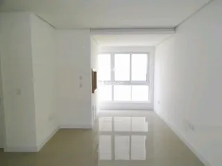 Vista interna de um ambiente com paredes brancas e uma janela.